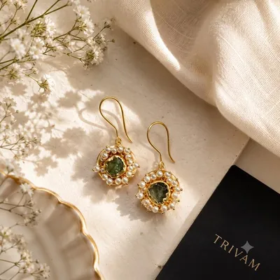 Vana — gold-toned drop earrings with raw green stones surrounded by pearl halos